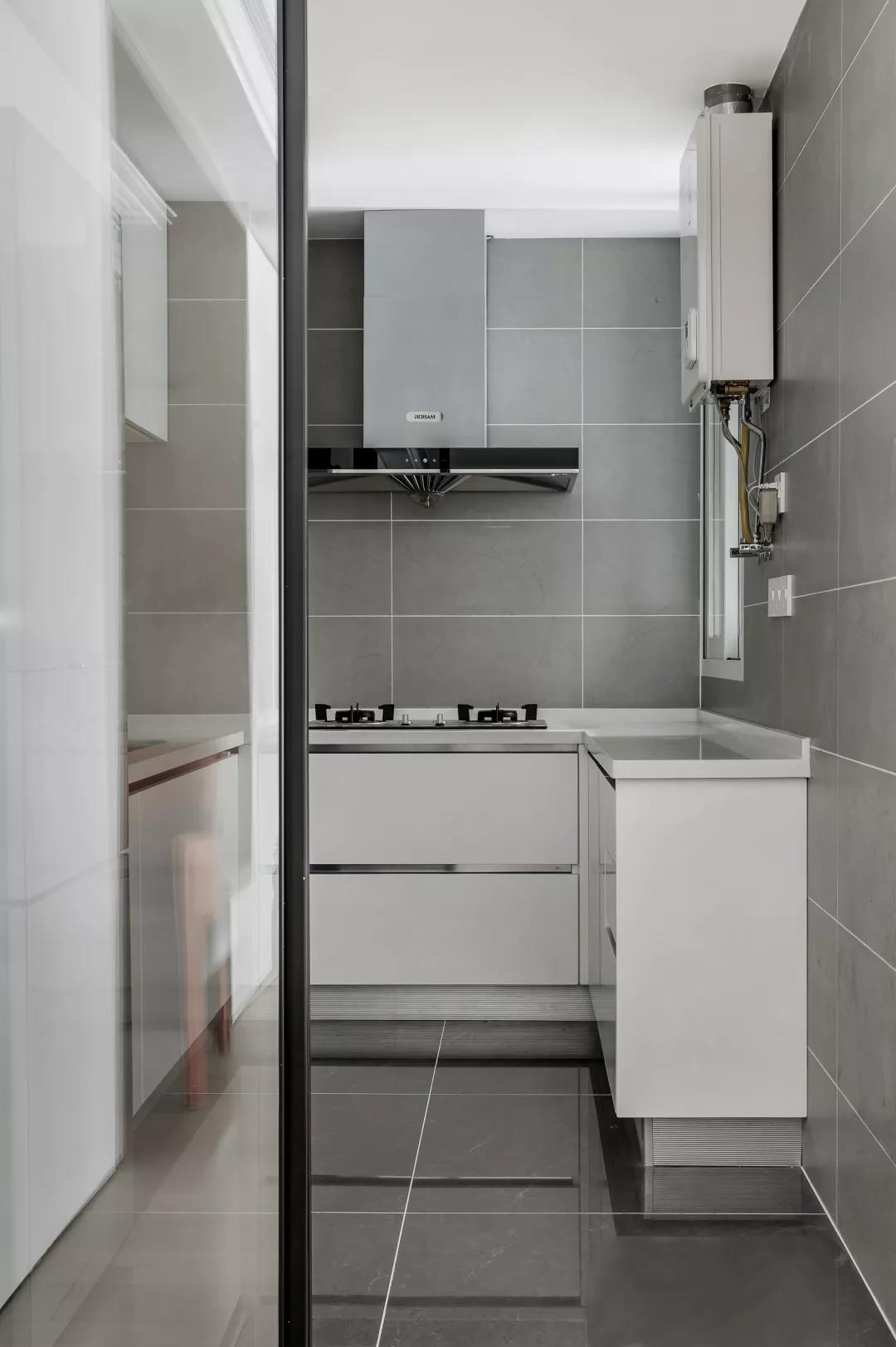 白色橱柜优雅纯净，搭配灰色背景，带来一种舒缓平和的烹饪氛围。