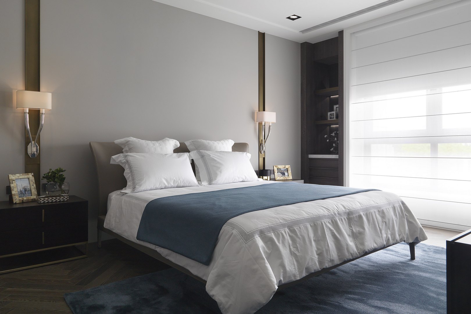 主卧空间以低饱和度色系为主，加入蓝色软装点缀，丰富了空间的层次感。