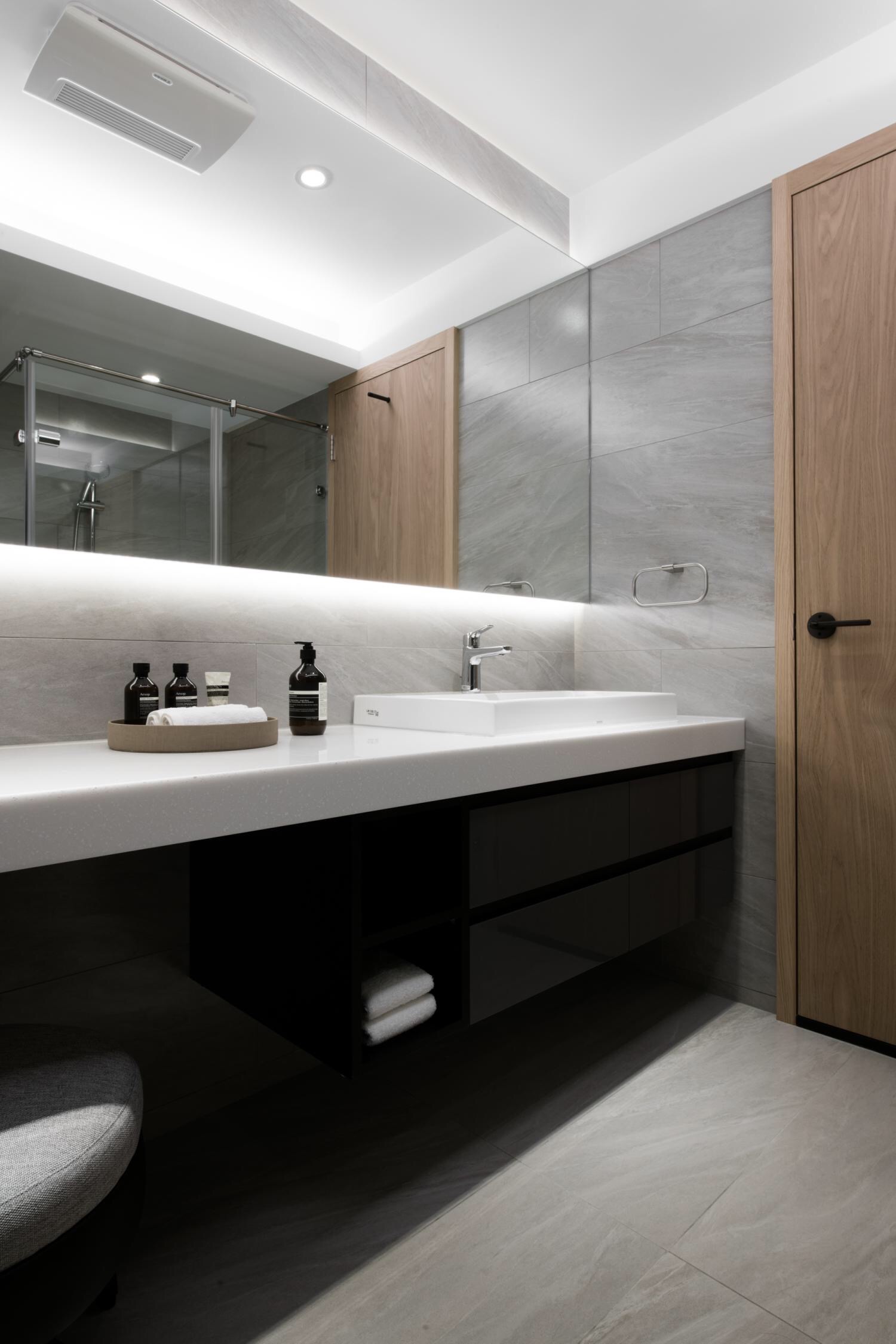 空间通铺灰色大理石瓷砖，搭配深色洗手台，让卫生间看起来简洁而又大方。
