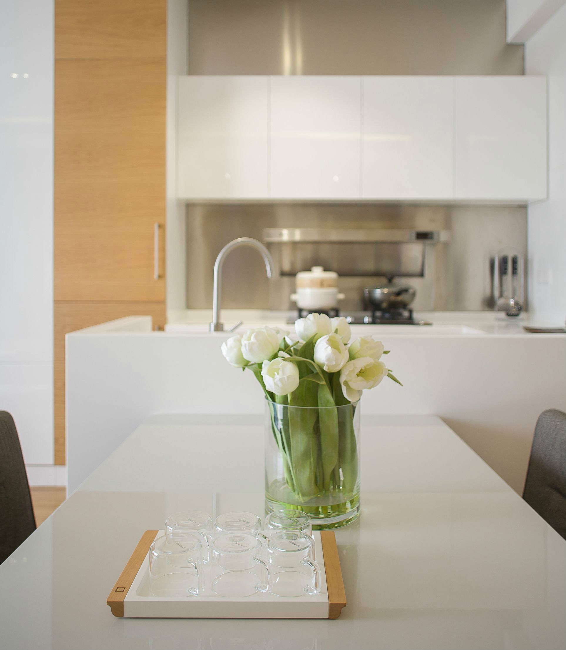 厨房空间中以白色为主，点缀木质元素的设计，表现出温馨洁净的氛围。