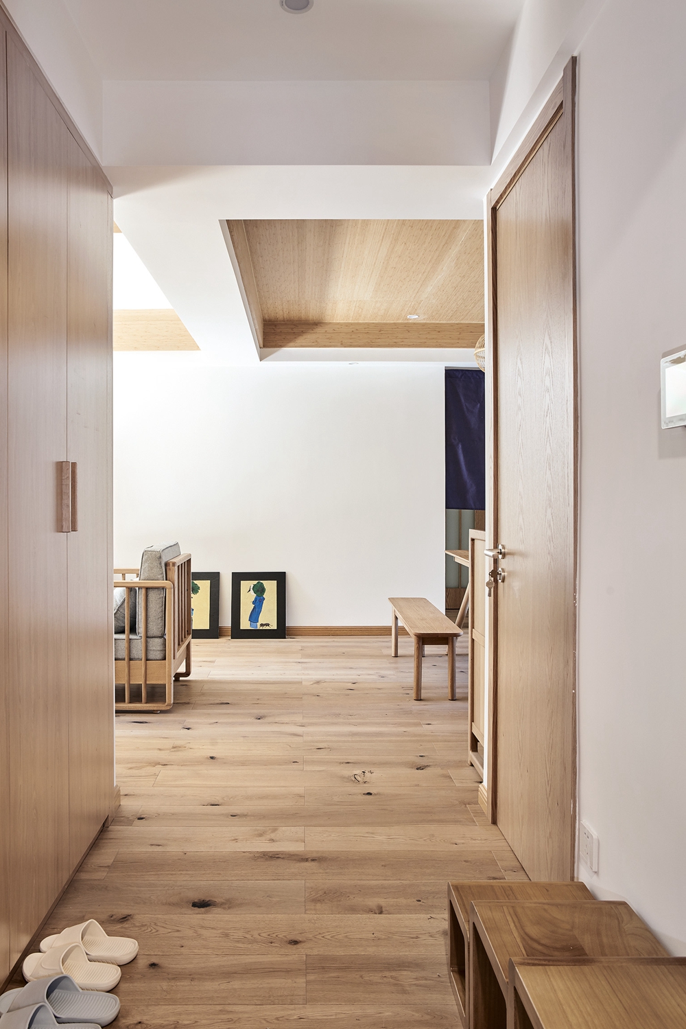 玄关面积不大，收纳柜顶墙设计简约大气，背景墙、地板选择原木色系，表现极其雅致大气，很有质感。