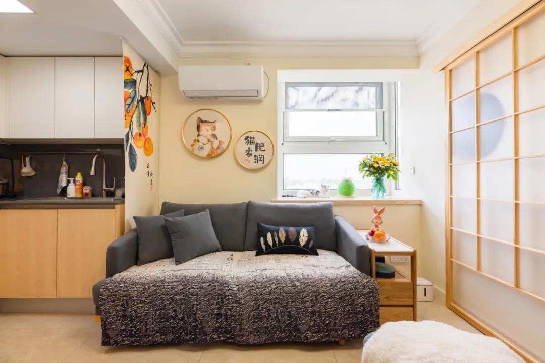 在暖色背景墙的基础上布置灰色布艺沙发，让空间显得更加实用简约而舒适。