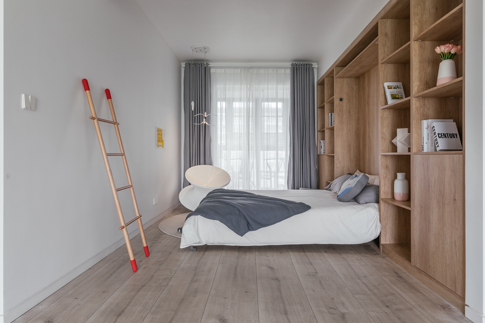 侧卧充满木质韵味，视觉感受层次分明，床头设计提升收纳里，空间呈现出简约现代风范。