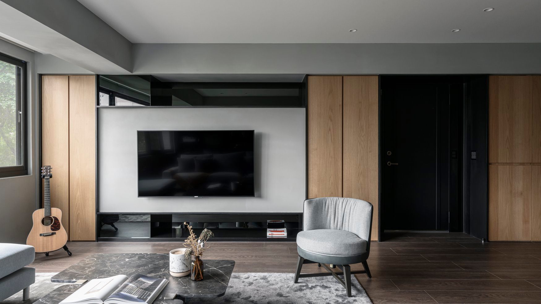 电视墙采用经典的黑白色系搭配，木质调的融入令背景充满层次感。