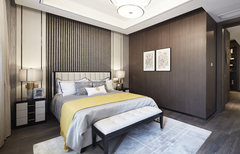 次卧背景墙简单且大气，木质衣柜带来肃静高雅的韵味，黄色的点缀令空间靓丽清澈。