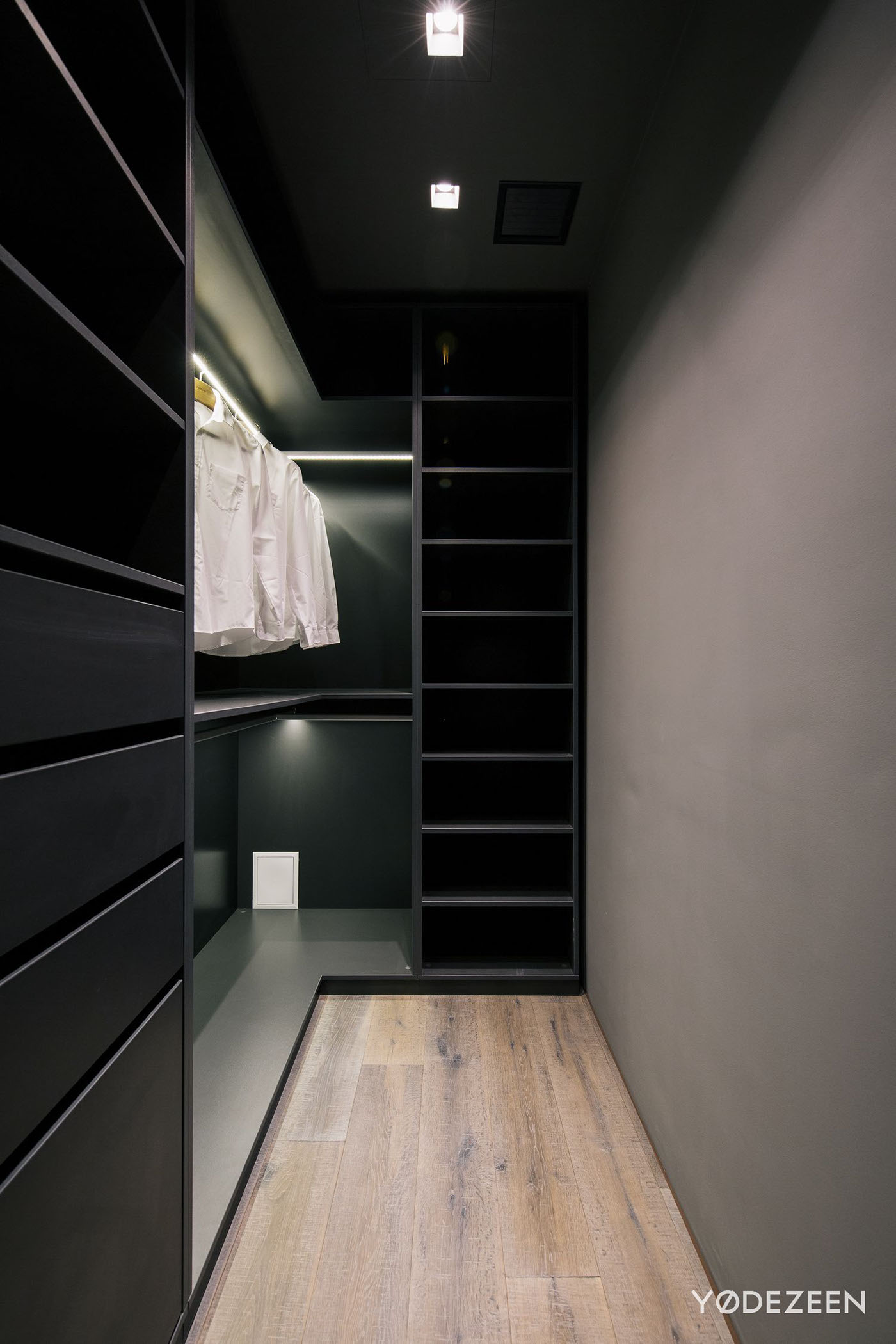 衣帽间衣柜以黑色为主，原木材质的地板为空间营造了别样的自然气息。