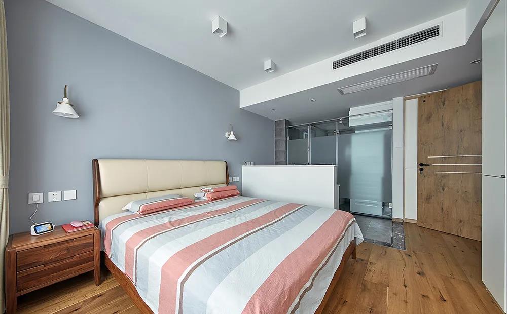 灰色背景墙搭配木质地板的设计，让卧室显得更加沉稳质朴，床品成为空间点缀。