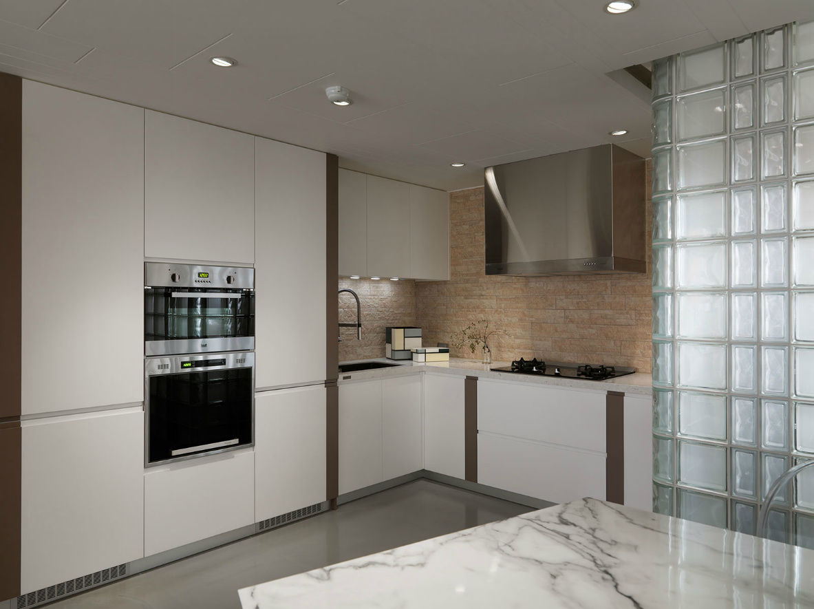 厨房在配色上采用沉稳的木色作为背景墙，使用白色橱柜和收纳柜点缀。