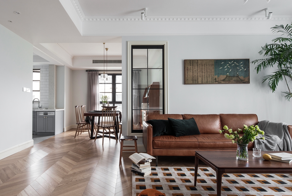 客厅通过简单的色彩搭配，皮质沙发加上个性地毯的设计，凸显出空间的美式感。