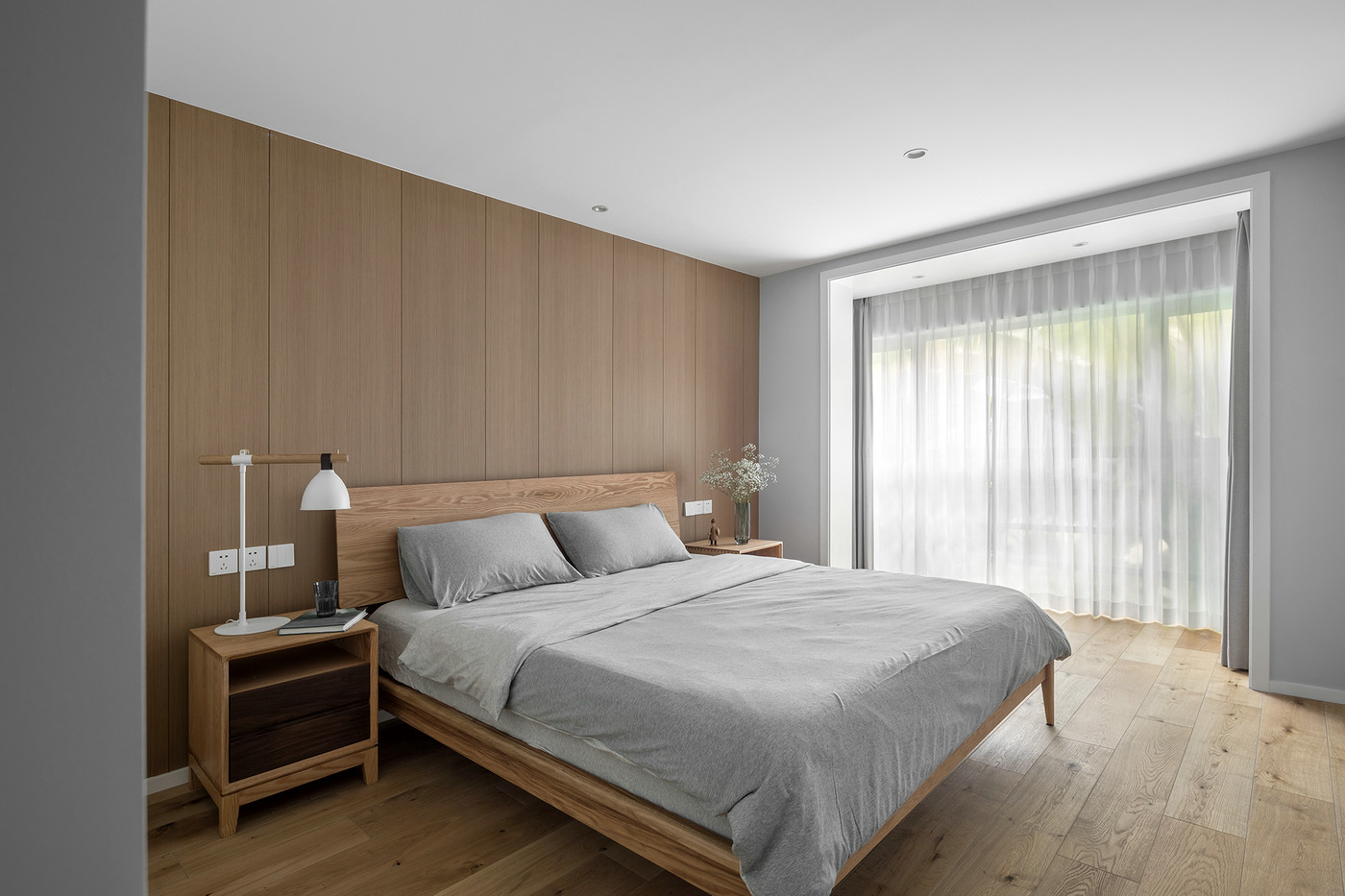 原木色床头背景墙搭配暖色灯光更显优雅，无吊灯设计使空间更加干净敞亮。