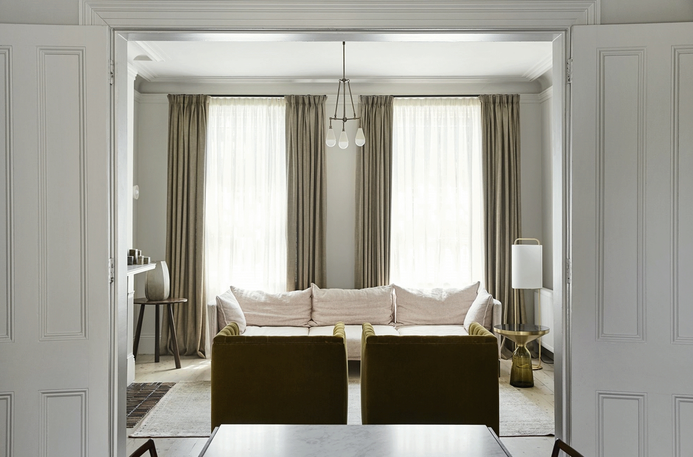 沙发设计简约素雅，在白色调的烘托下，布艺沙发、米色窗帘、金属点缀，都呈现出现代色彩美学。