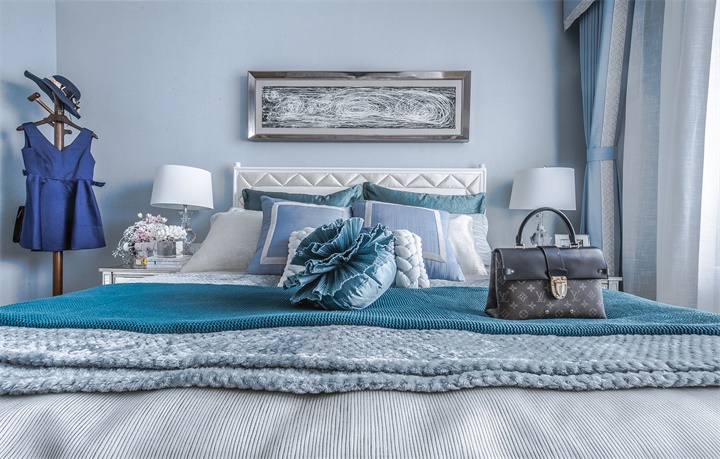 主卧床头设计简单，蓝白色感温润细腻，衣帽架放置于床头一侧，营造功能性。