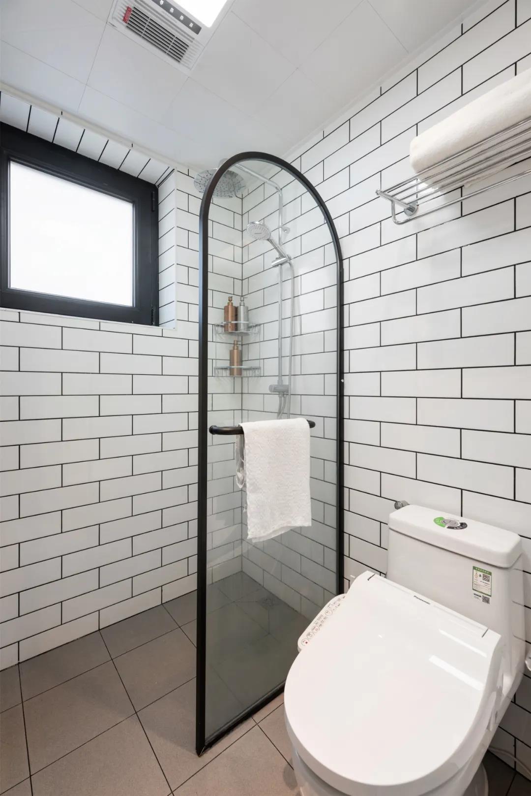卫浴空间整体以白色为主，局部使用黑框玻璃干湿分离，黑白两种颜色形成一种对比色。