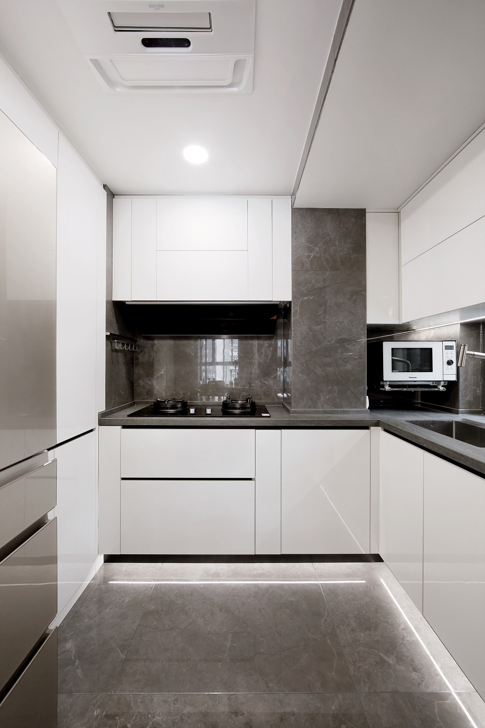 厨房空间以白色橱柜为主，动线规划明朗，空气中透着内敛而明亮的气息。