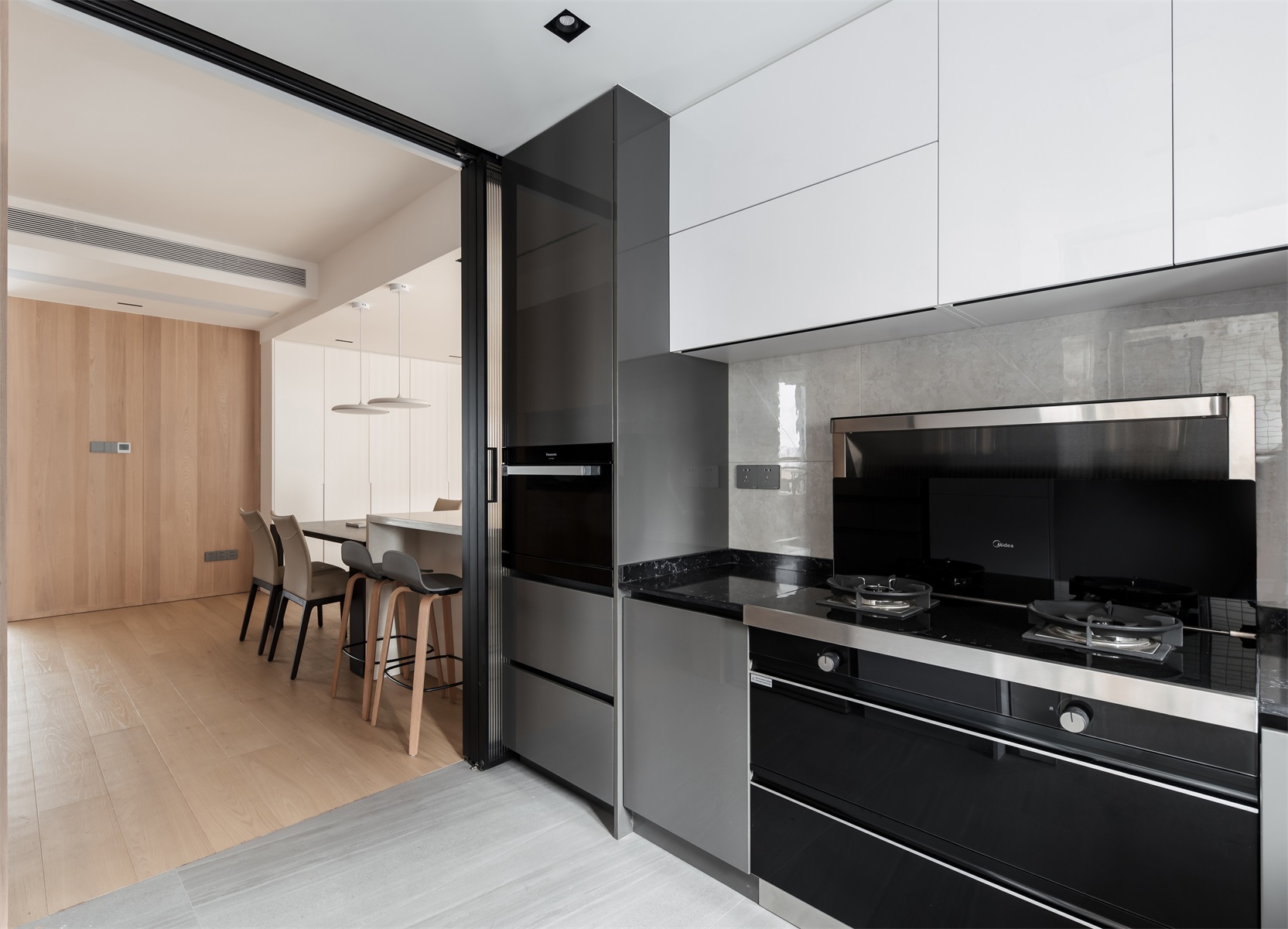厨房与餐厅相连，动线贯通，增强了空间的互动性，黑白橱柜设计经典耐看。