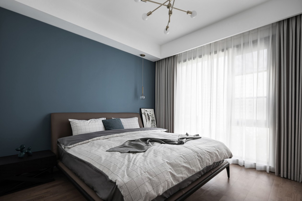 次卧背景摒弃了复杂的装饰设计，而是以蓝色涂料诠释优雅，呈现出内敛整洁的空间氛围。