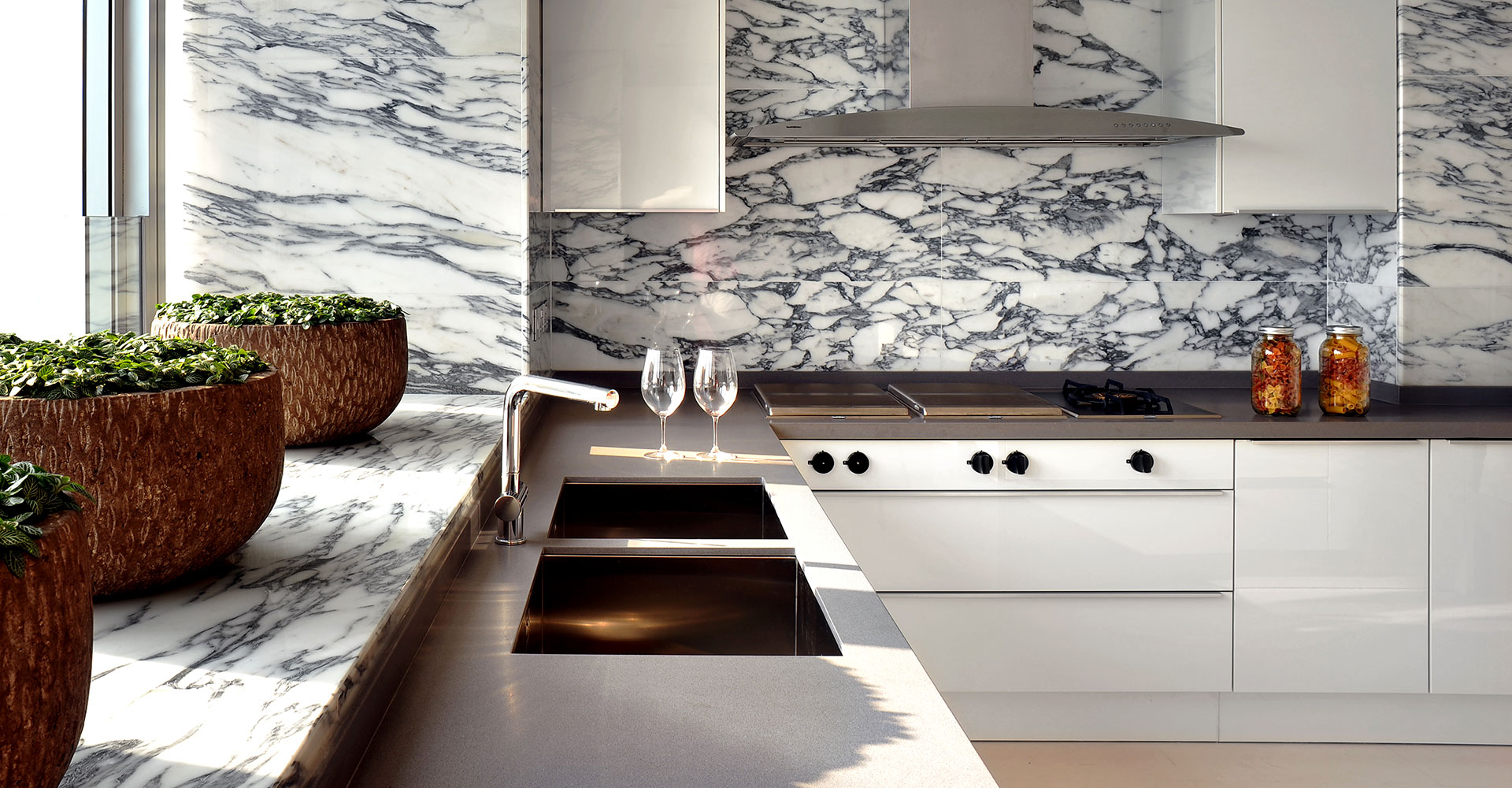 厨房背景采用大理石铺贴，自然的肌理增加了空间的层次感，配以白色橱柜，满目皆优雅。