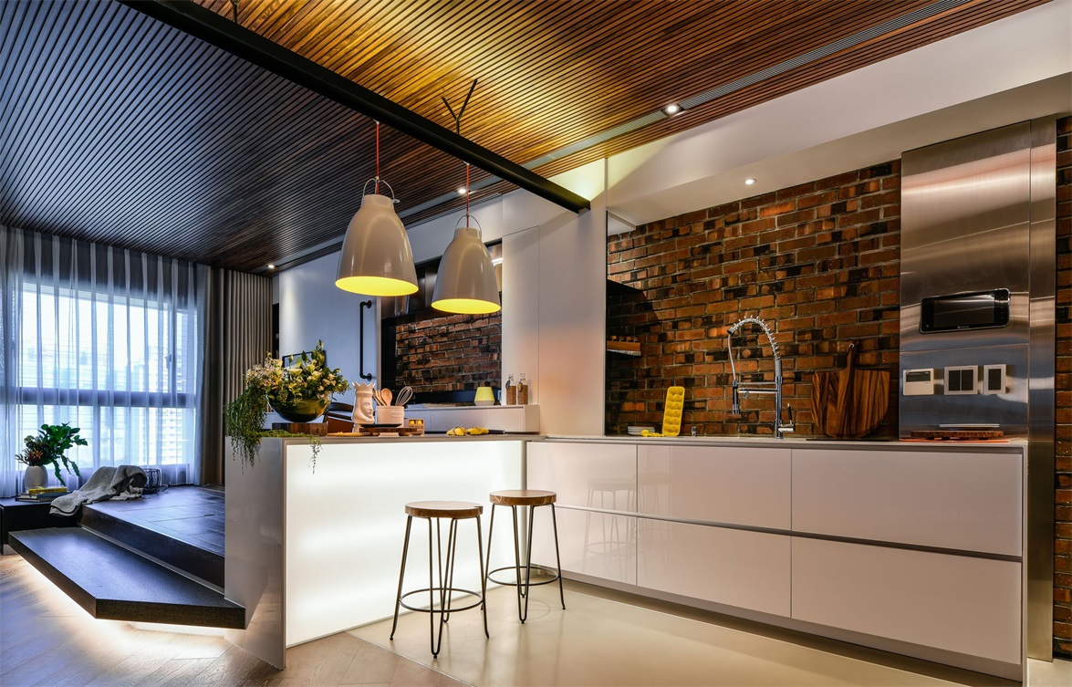 厨房的墙面铺贴了复古砖，褐色的墙砖搭配亮面的白色橱柜，带来一些温馨感。