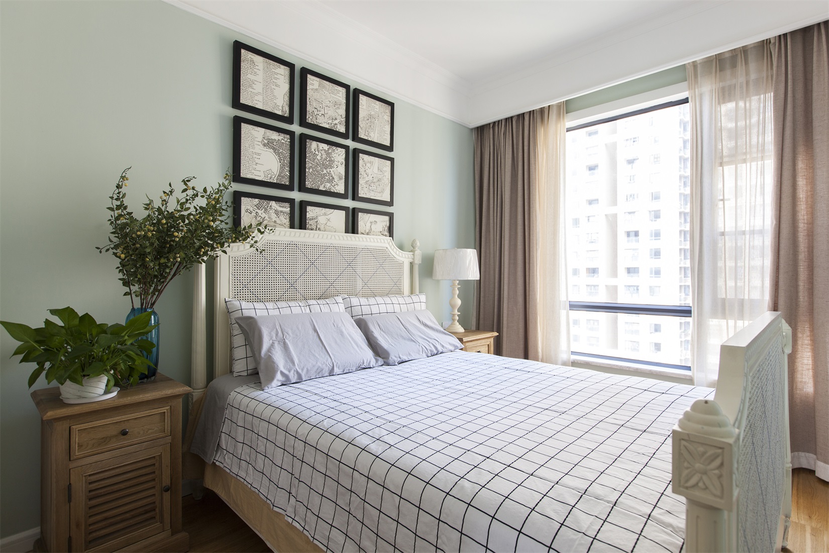 空间设计简约而富有层次感，床头背景墙相框装饰的手法，与床品格子造型相互呼应。