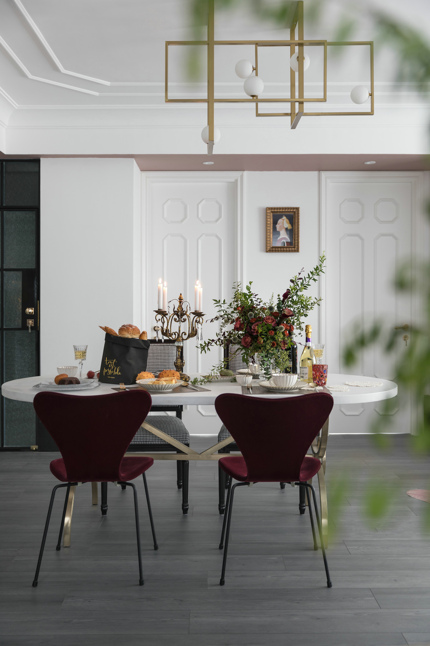餐桌背景墙采用白色护墙板打造，造型独特，在金属吊灯的光芒中荡漾出优雅与精致。