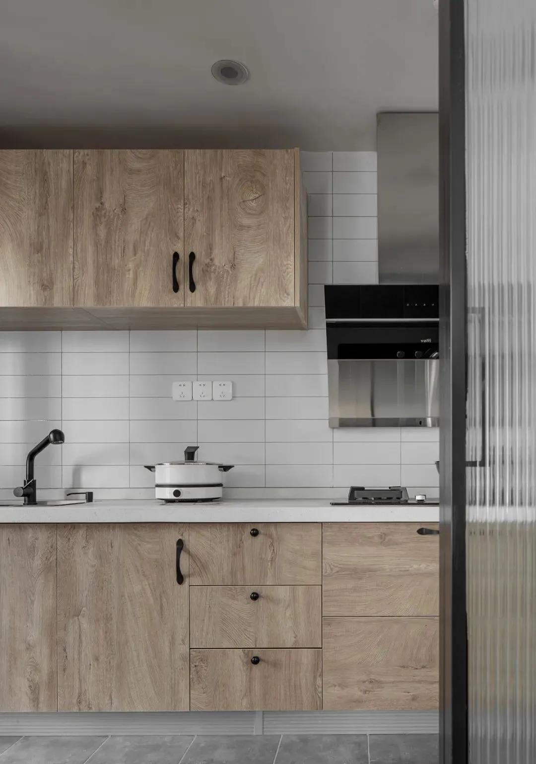 厨房顶柜与底柜都采用木质橱柜打造，在白色的空间中，显得简约而时尚。