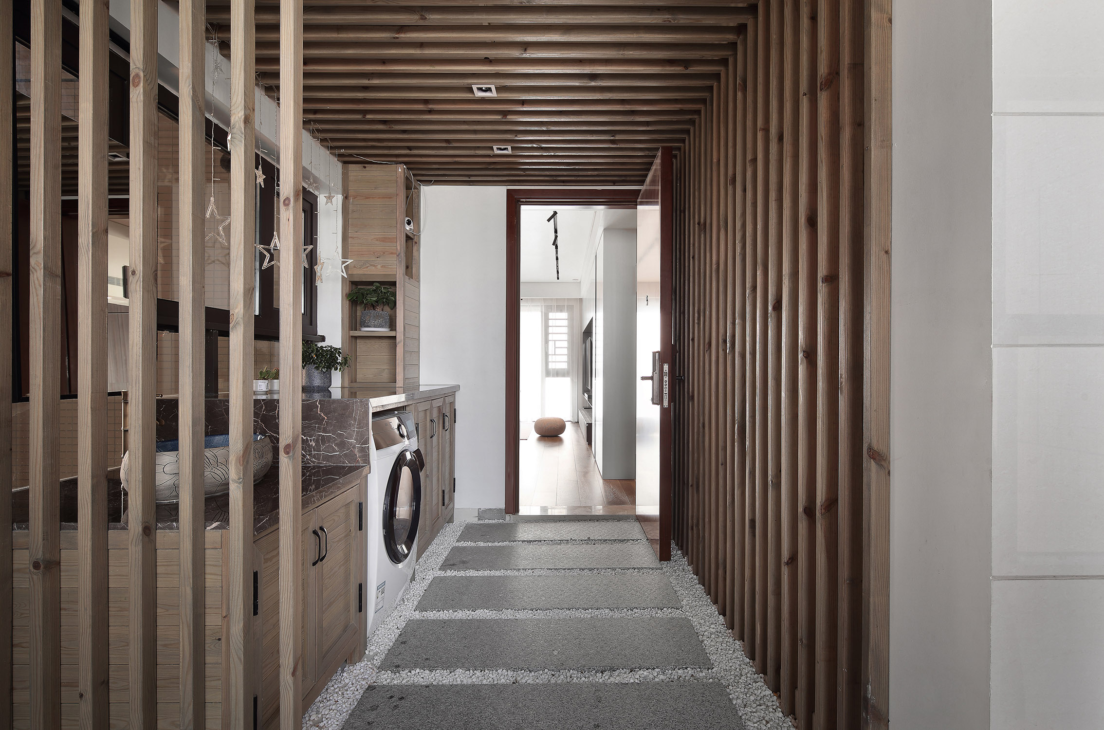 将玄关处打造为洗衣房是非常新颖的动线设计，木质调空间舒适大气。
