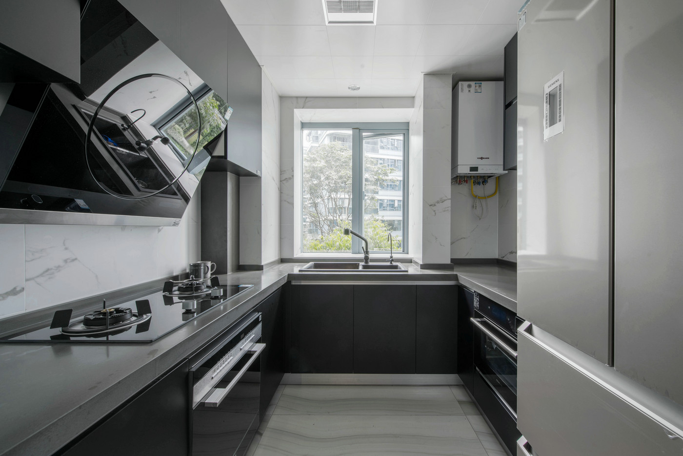 U型厨房设计动线合理完整，深色橱柜搭配浅色背景墙设计，呈现出高级质感。