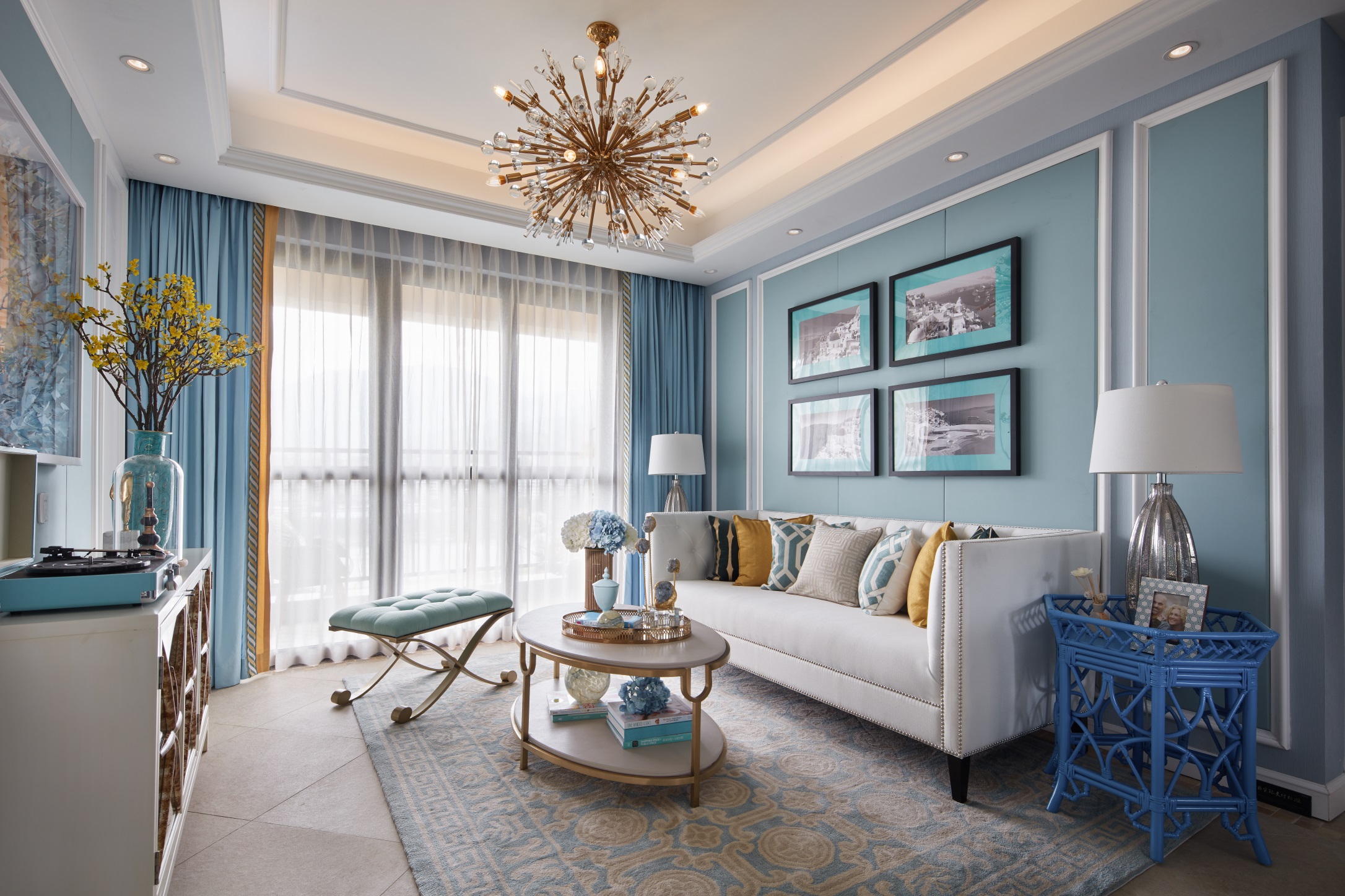 客厅明亮而舒适，设计师使用活跃的蓝色作为背景，并配以白色家具来装饰房间。