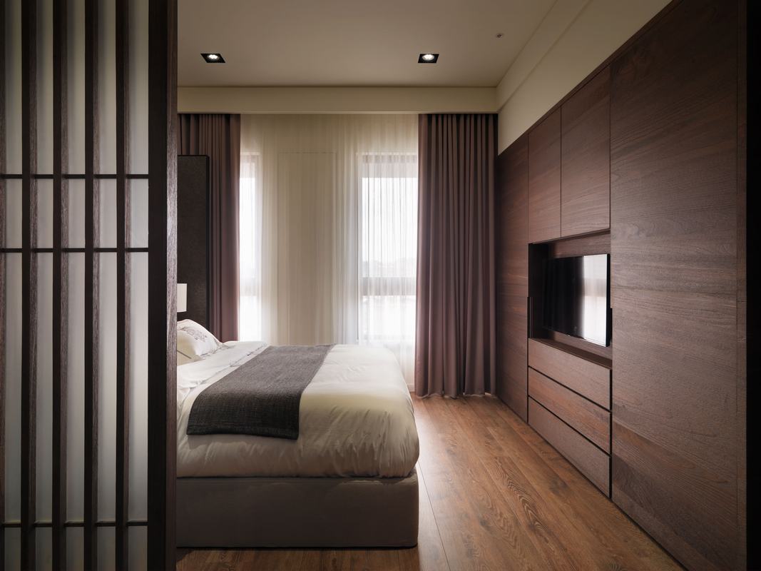 主卧床尾设计电视机位，木材版面设计看上去比较舒适，整体质感十足。