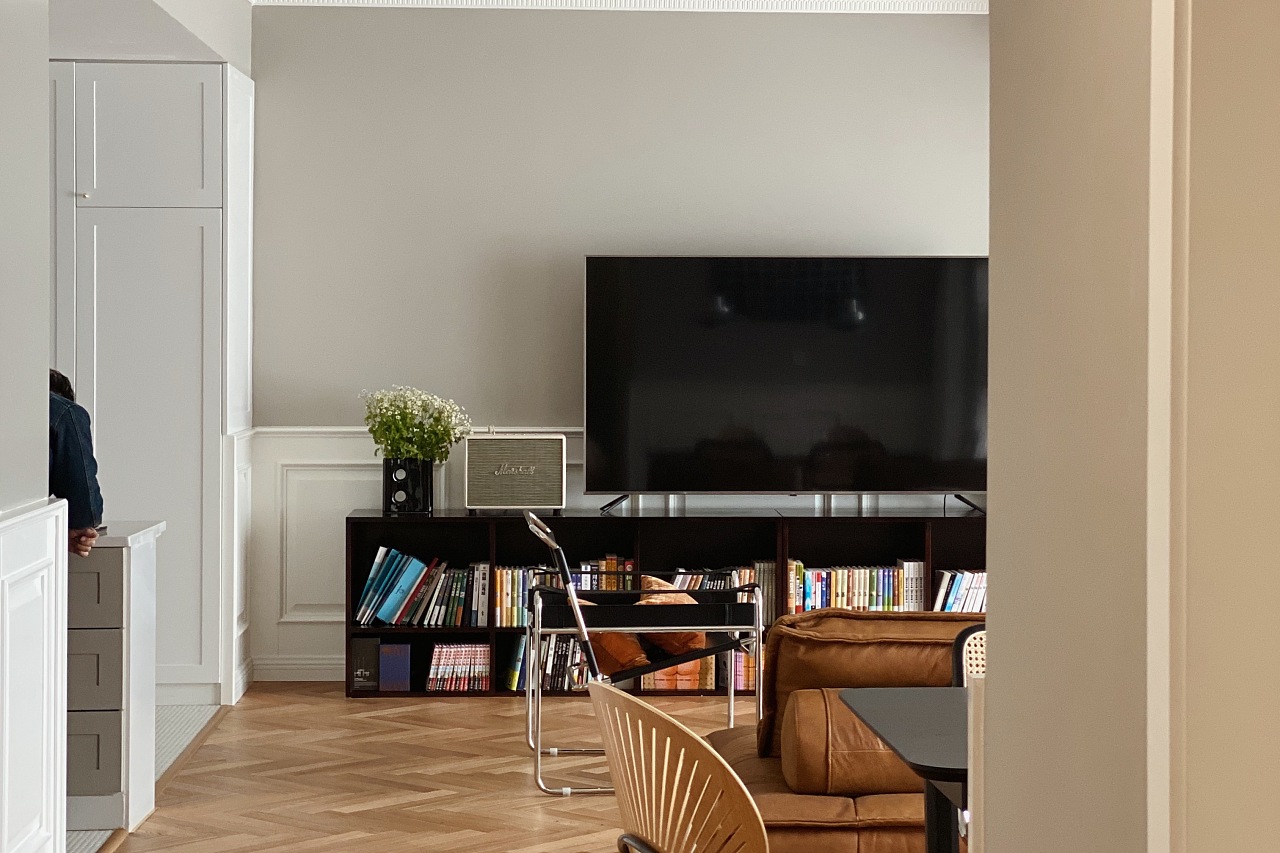 电视机背景墙分色设计，底部采用白色护墙板打造，凸显客厅的精致格调。