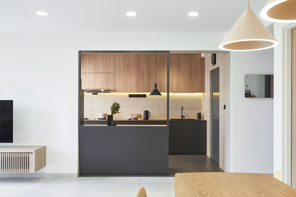 进门右侧为厨房，木色与黑色搭配使厨房充满精致感，局部灯带铺设，温馨雅致。
