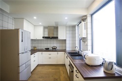 设计师采用简约设计手法，在厨房中配以白色橱柜和木质工作台，赋予了空间低调与高级。