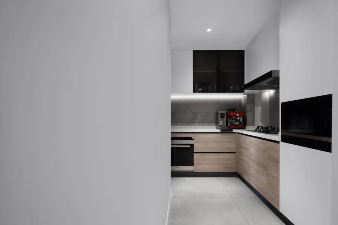 厨房设计感十足，木色橱柜和白色吊柜，让空间的舒适感自由散发。