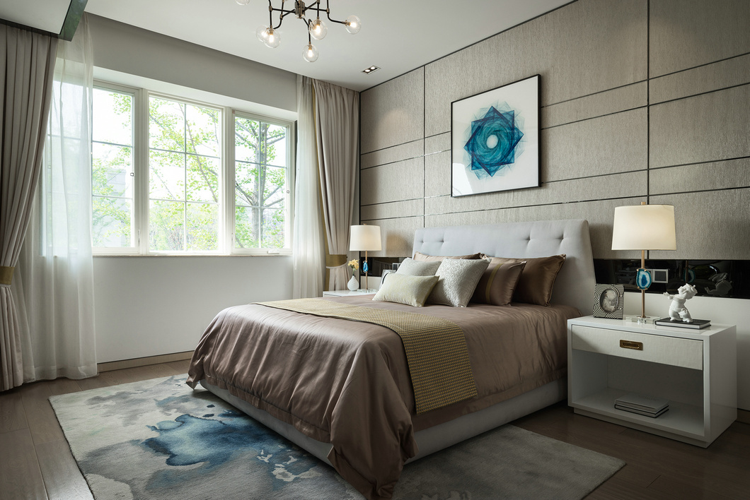 侧卧背景墙沿用咖色系，绸缎床品提升了空间的格调感，增加了轻奢韵味。