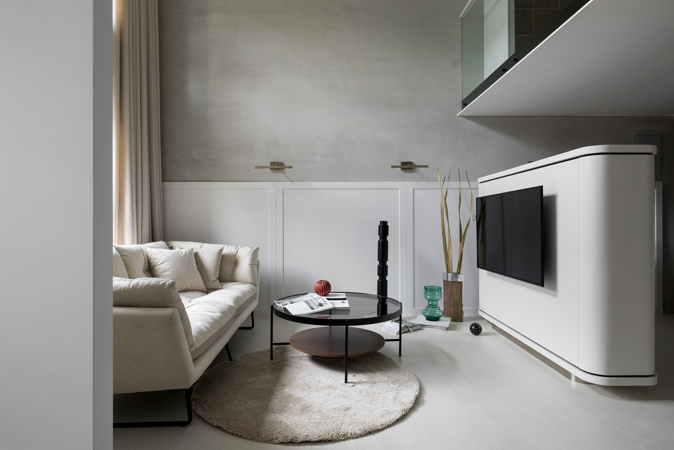 客厅以灰白色作为空间主色调，配以白色沙发，传递出温馨舒适的氛围。