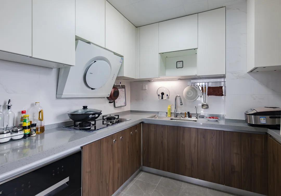 厨房空间选用轻巧的木色橱柜打造，吊柜设计为白色，不显得空间压抑。
