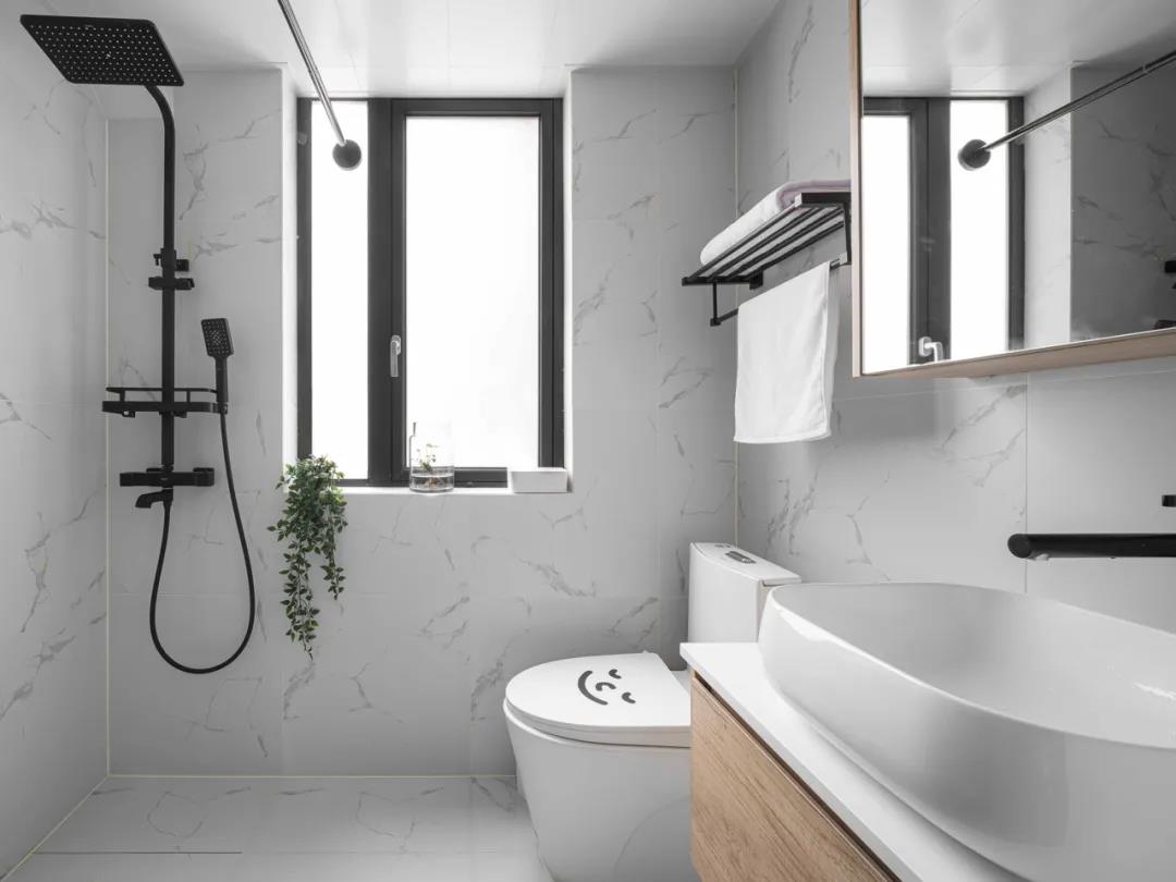 卫生间面积紧凑，未做干湿分离，大理石墙砖和白色洁具搭配，相得益彰。