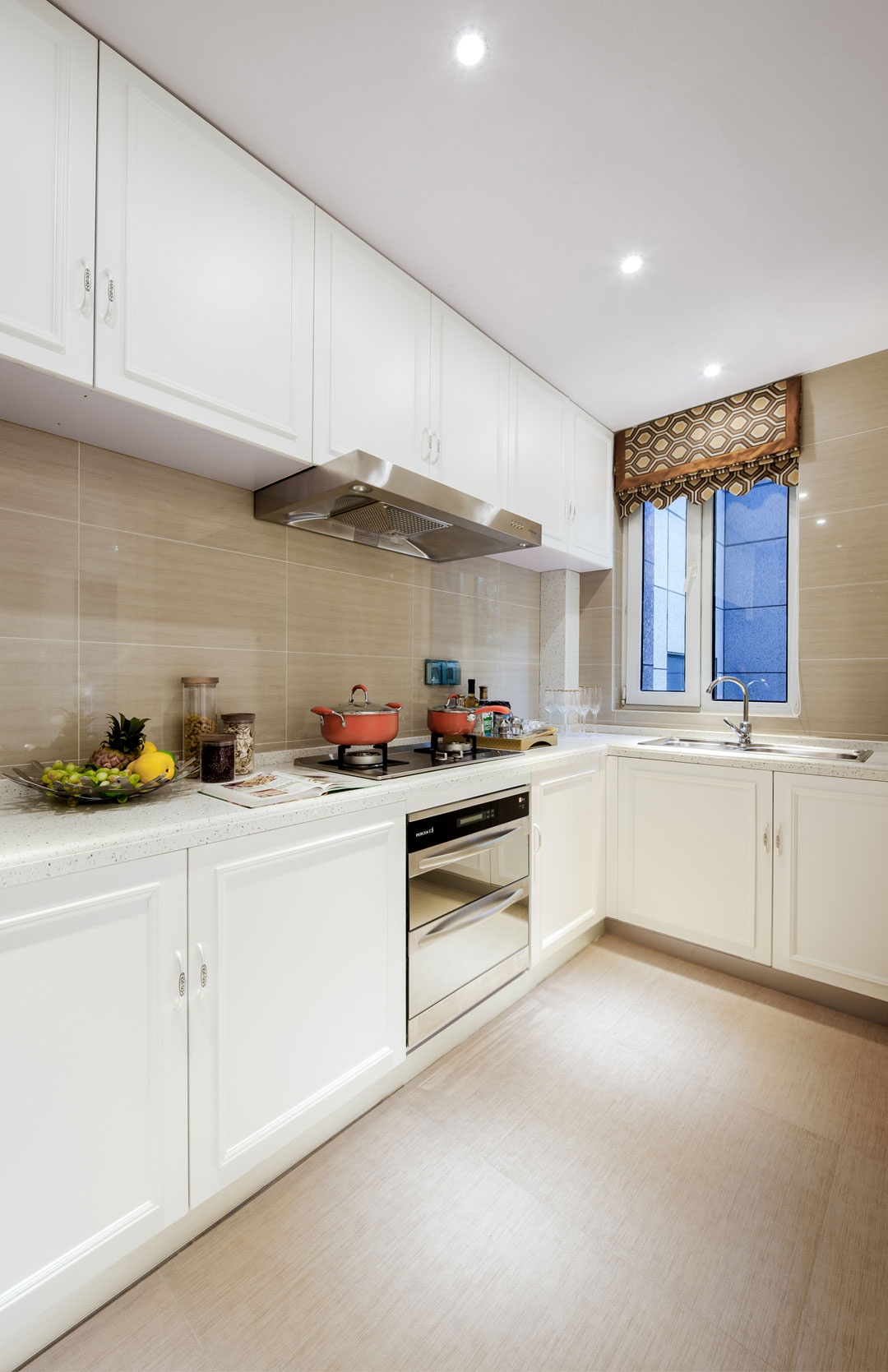 厨房空间使用白色橱柜搭配米色背景墙，冲击了眼球，在视觉上感到饱满。