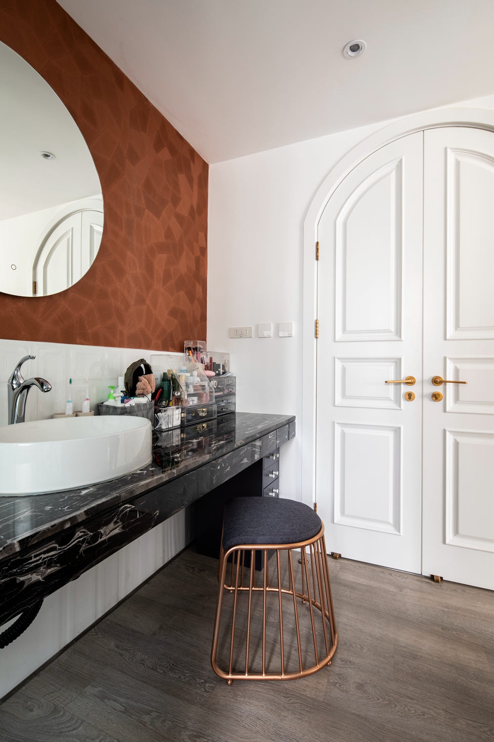 卫浴空间结构紧凑，墙面与地面采用灰色大理石铺贴，深色洗手台在其中显得精致典雅。