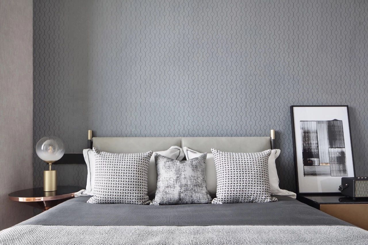 侧卧白灰色的床铺，搭配浅灰色背景墙，营造出丰富的空间层次，素雅又迷人。