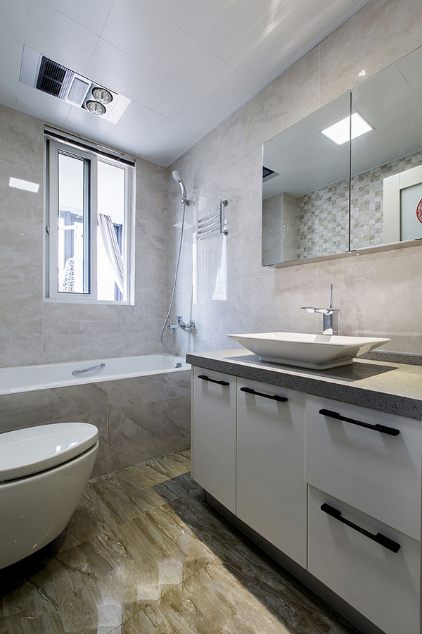 卫生间结构紧凑，使用大理石背景墙铺贴，搭配白色洁具和洗手台，空间优雅大气。