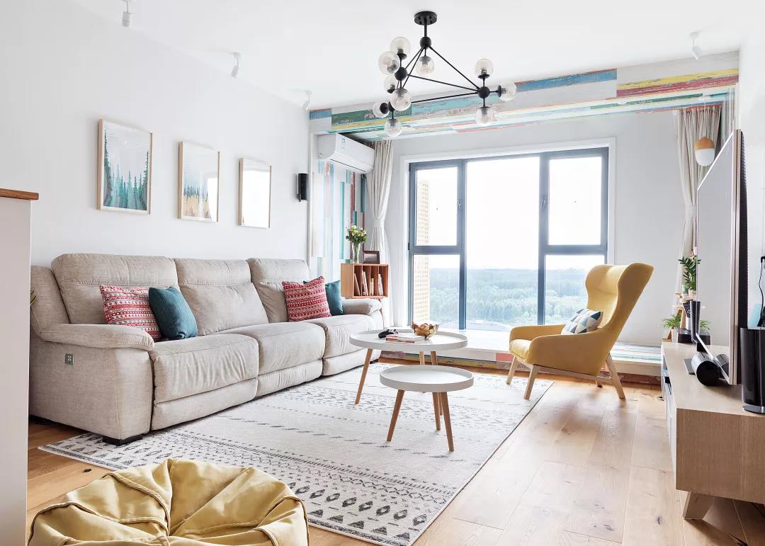 较好的落地窗带来开阔的既视感，布艺材质的沙发及软装提升了客厅颜值。