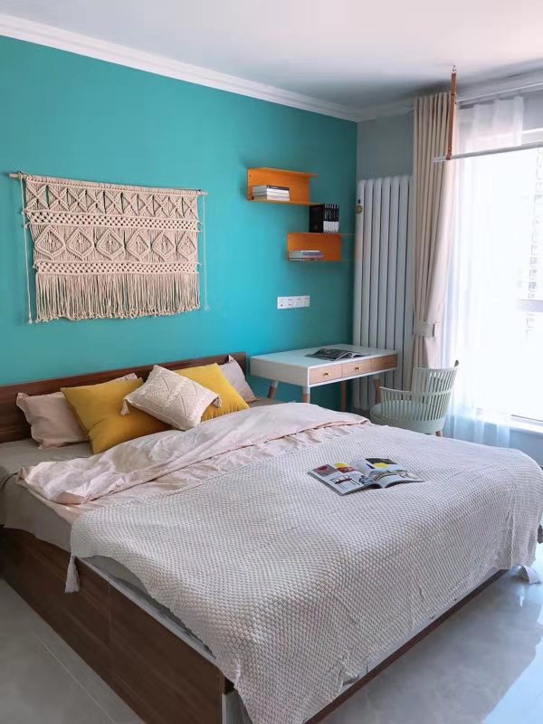 蓝色背景墙加上清新自然的木色床体，主卧空间配色简约雅致，毫不刻意。