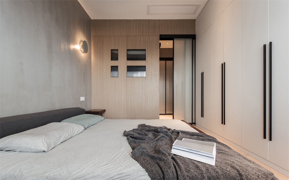在不够宽敞的次卧空间里，隐性衣柜令空间不感拥挤，提升了立面的简洁感。