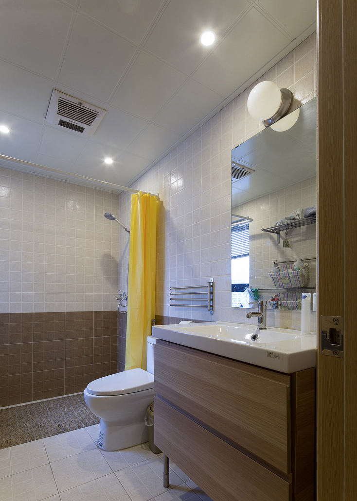 没有复杂设计的卫生间，只用一个亮色的浴帘就将空间色调提亮。