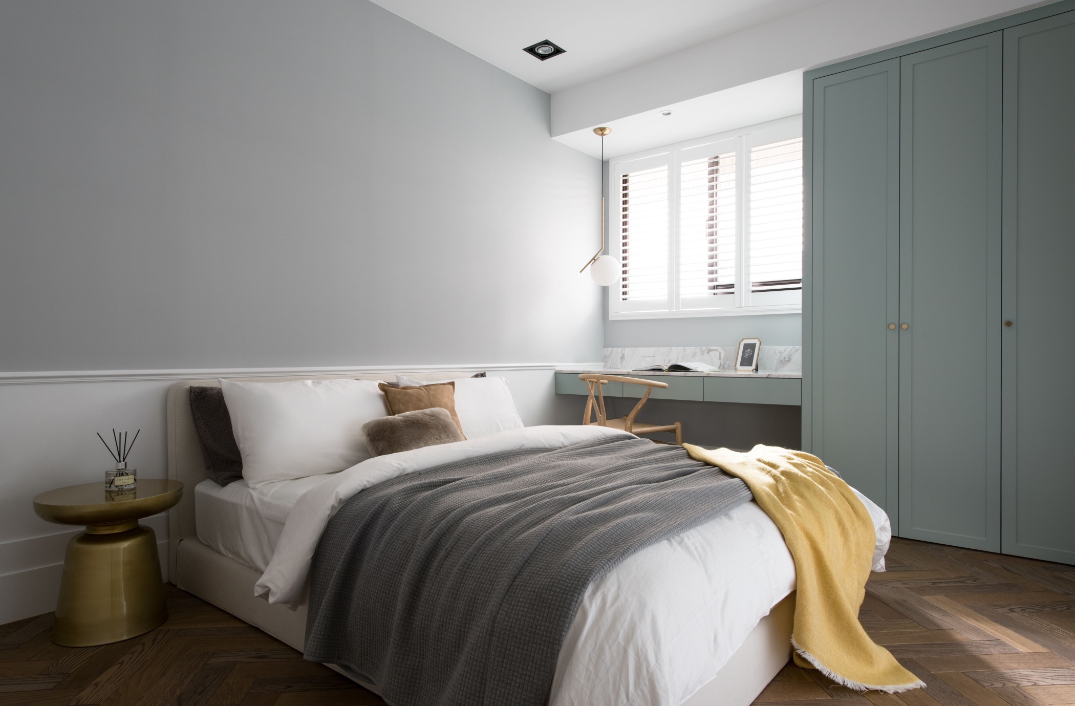 灰色布满整个主卧空间的背景墙，白色、灰色、黄色床品搭配，使空间静谧十足。