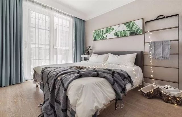 灰色与白色的结合令卧室宁静又浪漫，加之舒适的蓝色窗帘，空间显得更为优雅。