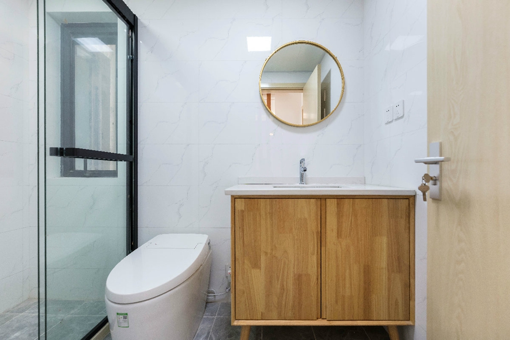 卫浴间做了干湿分离设计，木色洗手池在白色的空间中视感温润，营造出禅意情境。