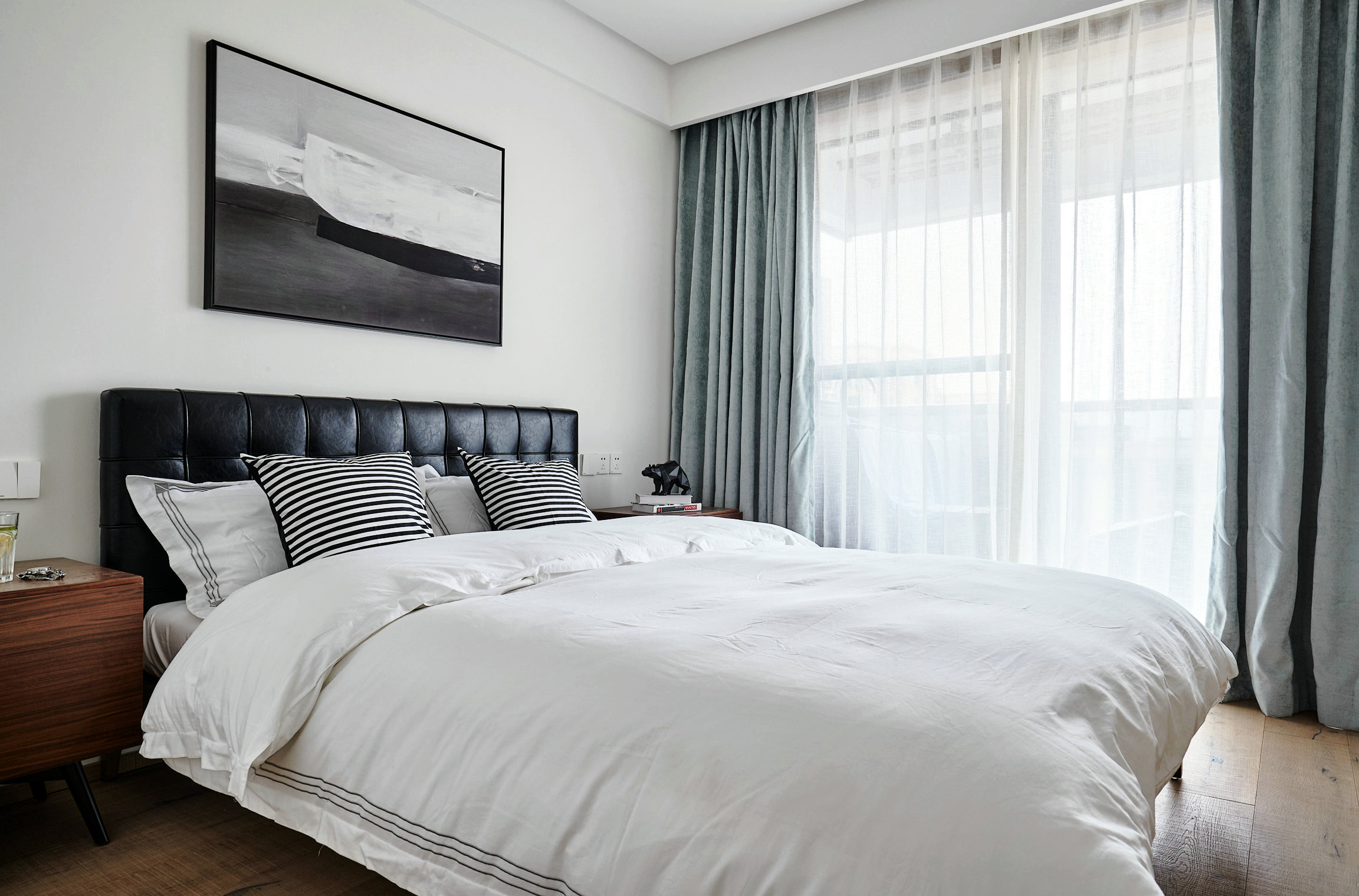 侧卧沿用白色主题，背景墙和床品都选用白色，装饰画与床头颜色相辅相成。