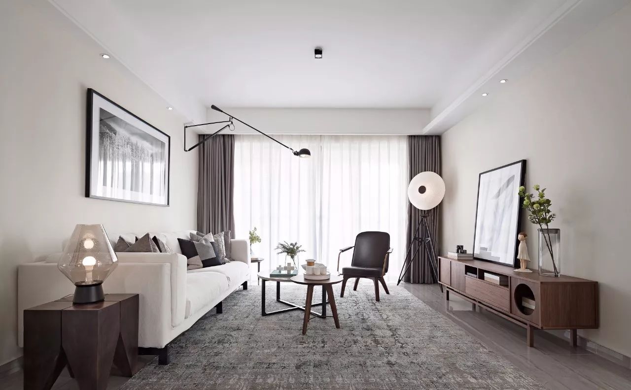客厅空间以白色为主，背景墙没有很复杂的设计，以米色为基调，搭配白色布艺沙发，洁净而明亮。